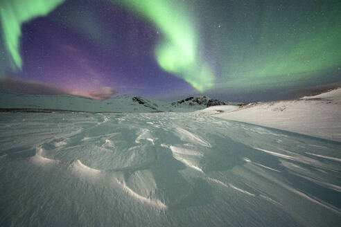 Gefrorener Schnee beleuchtet vom grünen Licht des Nordlichts (Aurora Borealis) in der kalten arktischen Nacht, Insel Mageroya, Nordkapp, Troms og Finnmark, Norwegen, Skandinavien, Europa - RHPLF18988