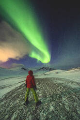 Man standing in the icy landscape admiring the Northern Lights (Aurora Borealis), Mageroya island, Nordkapp, Troms og Finnmark, Norway, Scandinavia, Europe - RHPLF18990