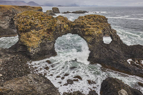 Ein Felsbogen zwischen Basalt-Lavafelsen bei Arnastapi, an der Küste der Halbinsel Snaefellsnes, Westisland, Polarregionen - RHPLF19003