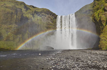 Ein permanenter Regenbogen in der Gischt des Wasserfalls Skogafoss, in der Nähe von Vik, Südisland, Polarregionen - RHPLF19024