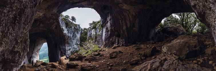 Malerischer Blick auf eine borstige Höhle und Berge in der Nähe wachsender Bäume im Baskenland - ADSF19553