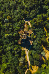 Aerial view of aged stone building surrounded by lush green woods near narrow pathway in Basque Country - ADSF19556