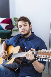 Musiker spielt Gitarre bei der Arbeit im Studio - GIOF10187