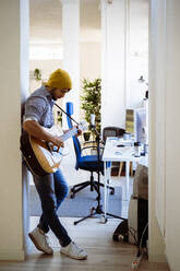 Gitarrist spielt Gitarre im Stehen im Studio - GIOF10204