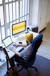 Berufstätiger mit Laptop im Studio sitzend - GIOF10212