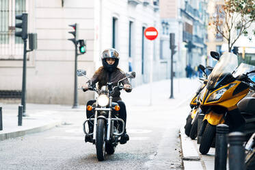 Three men wearing open face crash helmets and goggles riding cafe racer  motorcycles along rural road Stock Photo - Alamy