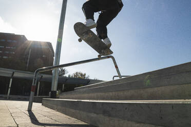 Mann fährt mit dem Skateboard auf dem Geländer eines Skateboardparks - PNAF00404