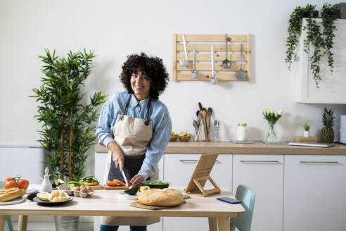 Portrait of young woman preparing vegan sandwiches in kitchen - GIOF10358