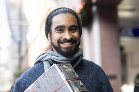 Close-up portrait of bearded young man with Christmas present stock photo