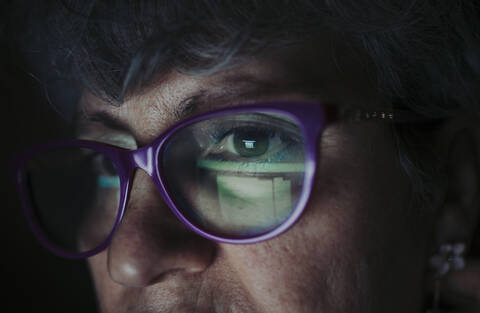 Close-up of senior woman wearing eyeglasses working at home stock photo