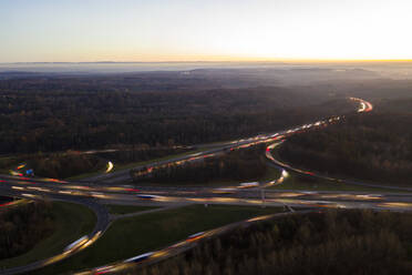 Deutschland, Baden-Württemberg, Stuttgart, Luftaufnahme von Fahrzeuglichtspuren auf der Bundesautobahn 8 bei Sonnenuntergang - WDF06441