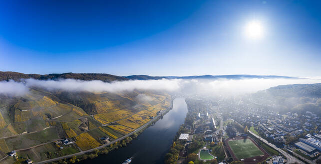 Deutschland, Rheinland-Pfalz, Bernkastel-Kues, Blick aus dem Hubschrauber auf die Stadt am Fluss und die Weinberge am Hang an einem nebligen Herbstmorgen - AMF08897