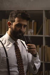 Porträt eines bärtigen Mannes, der Pfeife raucht - GIOF10396