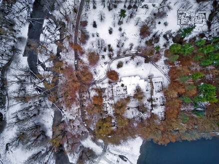 Luftaufnahme einer Landstraße, die sich durch eine schneebedeckte Landschaft zieht - KNTF06047