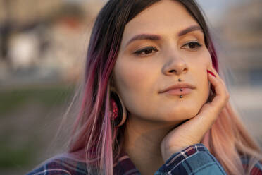 Hipster woman with hand on chin day dreaming outdoors - VPIF03384