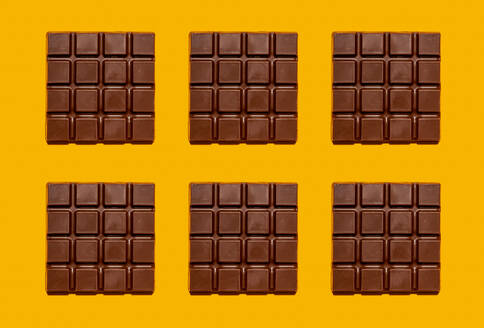Muster von Schokoladentafeln vor gelbem Hintergrund - GEMF04523