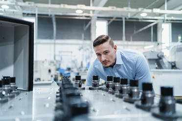 Male professional examining machine in industry - DIGF13646