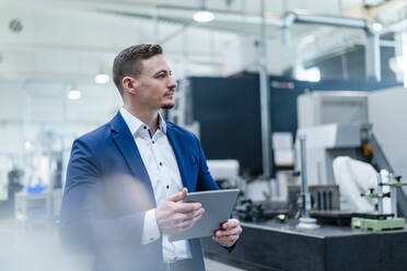 Business man with digital tablet looking around in in industry - DIGF13672