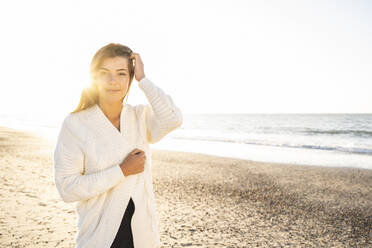 Schöne Frau steht am Strand gegen den klaren Himmel an einem sonnigen Tag - UUF22346