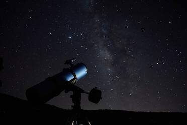 Modernes optisches Teleskop gegen wolkenlosen dunklen Himmel mit leuchtenden Sternen bei Nacht - ADSF19696