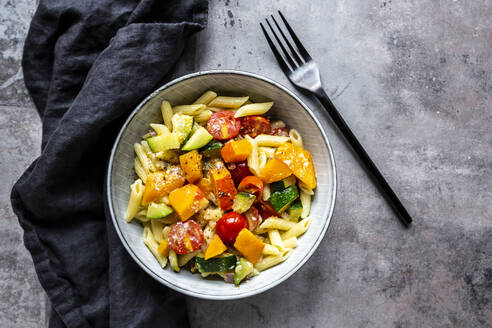 Bowl of vegan pasta with pumpkin, tomatoes and zucchini - SARF04646