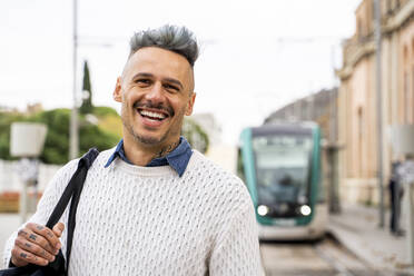 Smiling male commuter at train station - AFVF07924