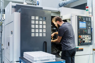 Technician repairing machine while standing at industry - DIGF13726