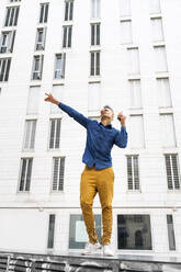 Mann tanzt gegen weißes Gebäude - AFVF07976