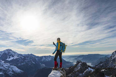 Älterer männlicher Wanderer, der sein Smartphone benutzt, während er auf dem Gipfel eines Berges steht, Orobic-Alpen, Lecco, Italien - MCVF00703