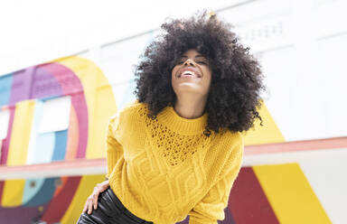 Cheerful woman with eyes closed smiling while standing outdoors - JCCMF00389