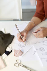 Weibliche Designerin zeichnet auf Papier am Schreibtisch im Atelier - VEGF03423