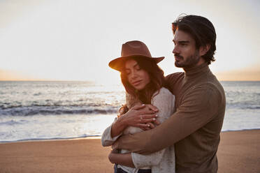 Man embracing woman from behind while standing at beach - VEGF03467