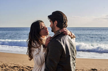 Couple doing romance while standing on beach - VEGF03516