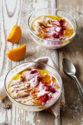 Two bowls of curd cheese raspberries and persimmons - EVGF03862