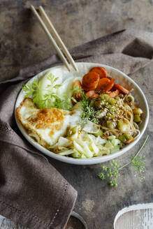 Schale mit Soba-Nudeln mit Kohl, Karotten, Kohlrabi, Spiegelei und Kräutern - EVGF03868