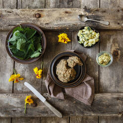 Kartoffelsalat, frische Brennnessel, Kräuterbutter und gelbe Blütenköpfe - EVGF03869