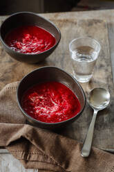 Glass of water and two bowls of beet soup - EVGF03872