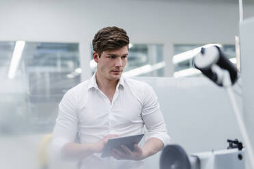 Männlicher Ingenieur mit digitalem Tablet bei der Arbeit in einer Fabrik - DIGF13783