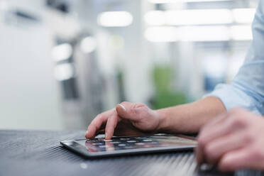 Male professional using digital tablet on desk in industry - DIGF13874