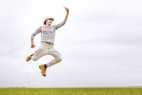 Young man taking selfie mid-jump stock photo