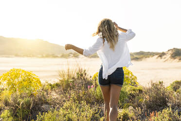 Woman running toward beach during sunset - SBOF02316