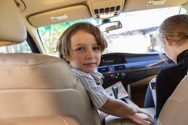 Young boy looking at camera in parked car. - MINF15460