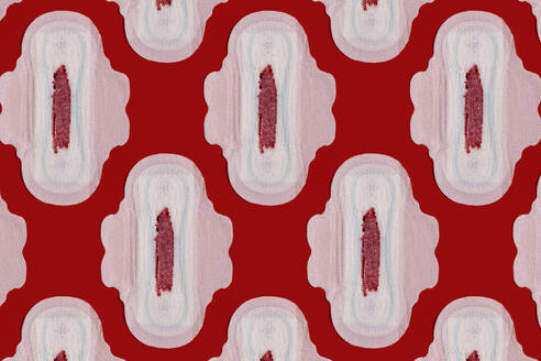 Muster von blutbefleckten Damenbinden vor rotem Hintergrund - GEMF04537
