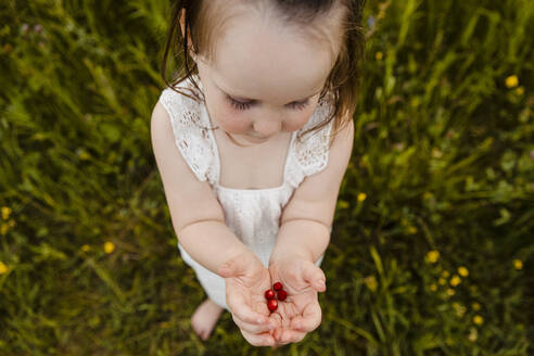 Niedliches kleines Mädchen hält einen Strauß frisch gepflückter Erdbeeren - AWAF00020