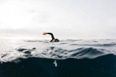 Mann schwimmt allein im Meer - JRFF04991