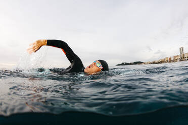 Mann schwimmt allein im Meer - JRFF04992