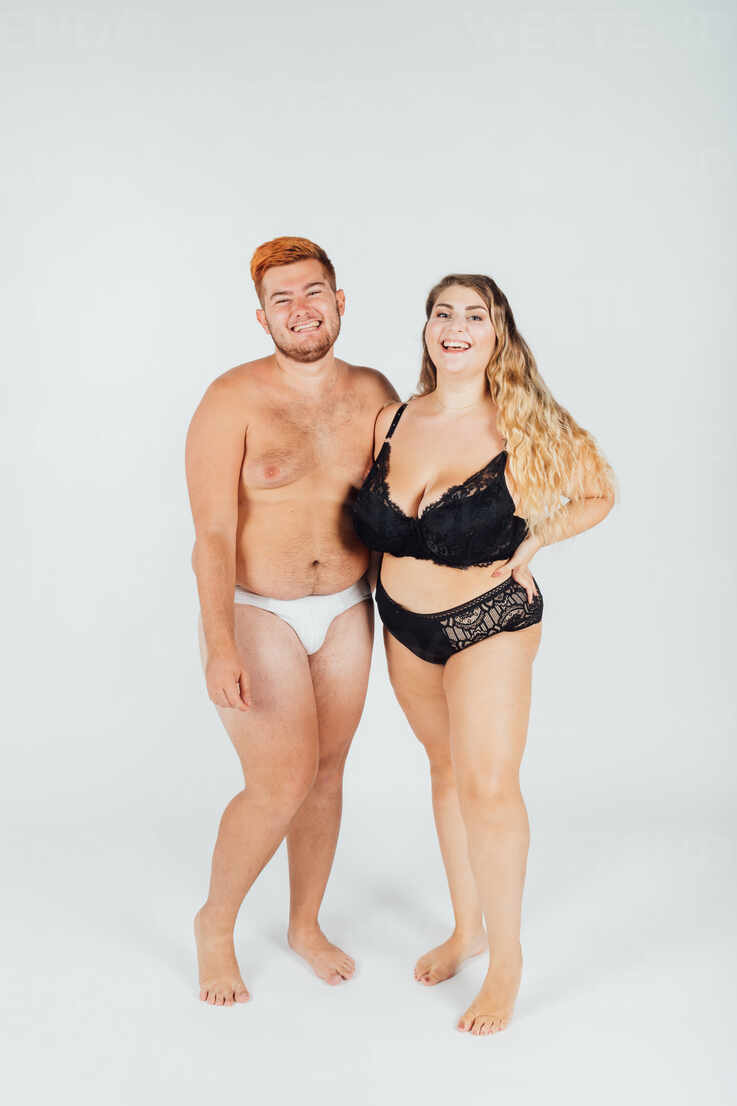 Happy young couple wearing underwear, full length stock photo