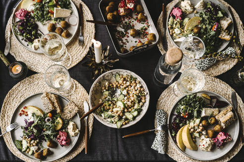 Directly above shot of food in plate by drinking glass arranged on dining table during social event - MASF21197