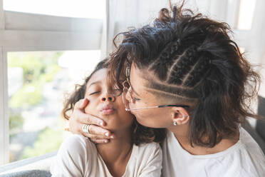 Mother kissing daughter on cheek - JAQF00121