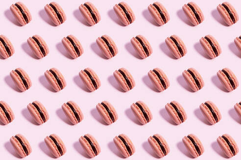 Muster von rosa Makronen Kekse gegen rosa Hintergrund - GEMF04549